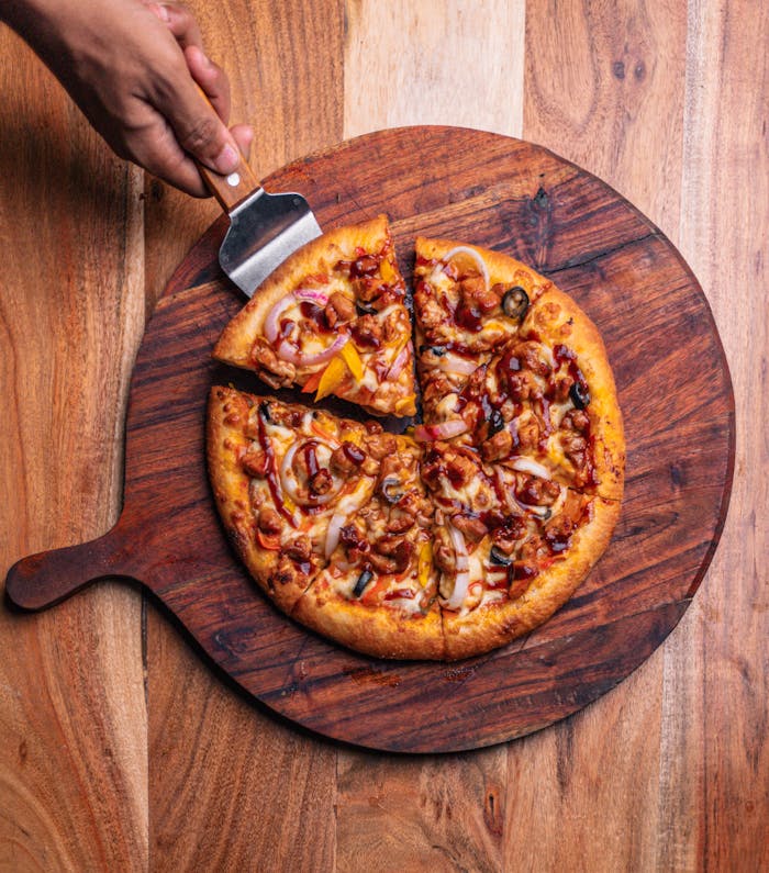 Top view of a freshly sliced Italian pizza on a wooden board, ready to serve.