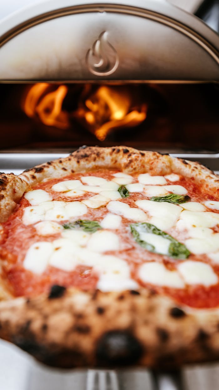 Close-up of a delicious pizza baking in a wood-fired oven, capturing the perfect culinary moment.