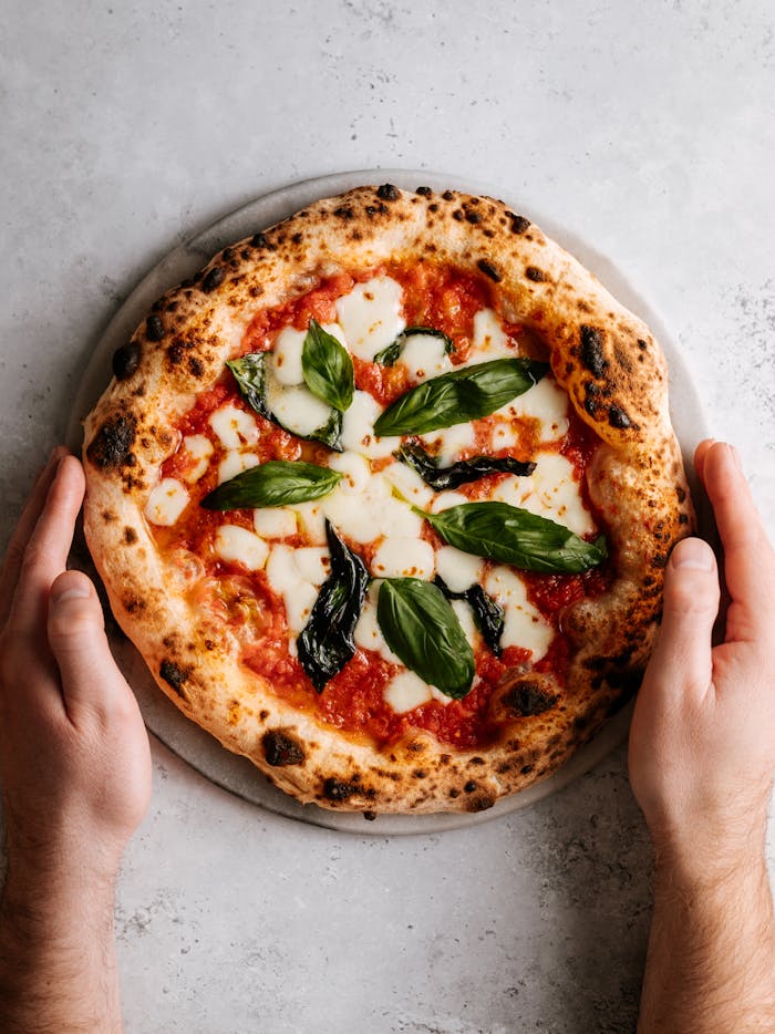 Delicious Margherita pizza with fresh basil and mozzarella, captured from above.